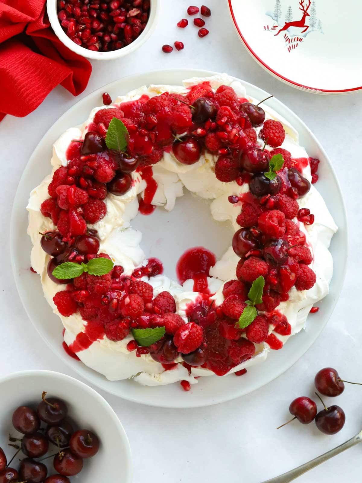 Stunning dessert of Christmas Wreath Pavlova on a table, ready to be eaten.