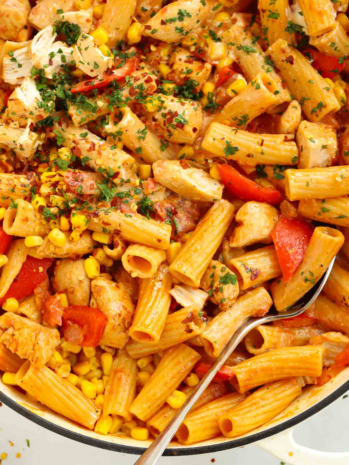 Close up of a big pan full of peri peri chicken pasta