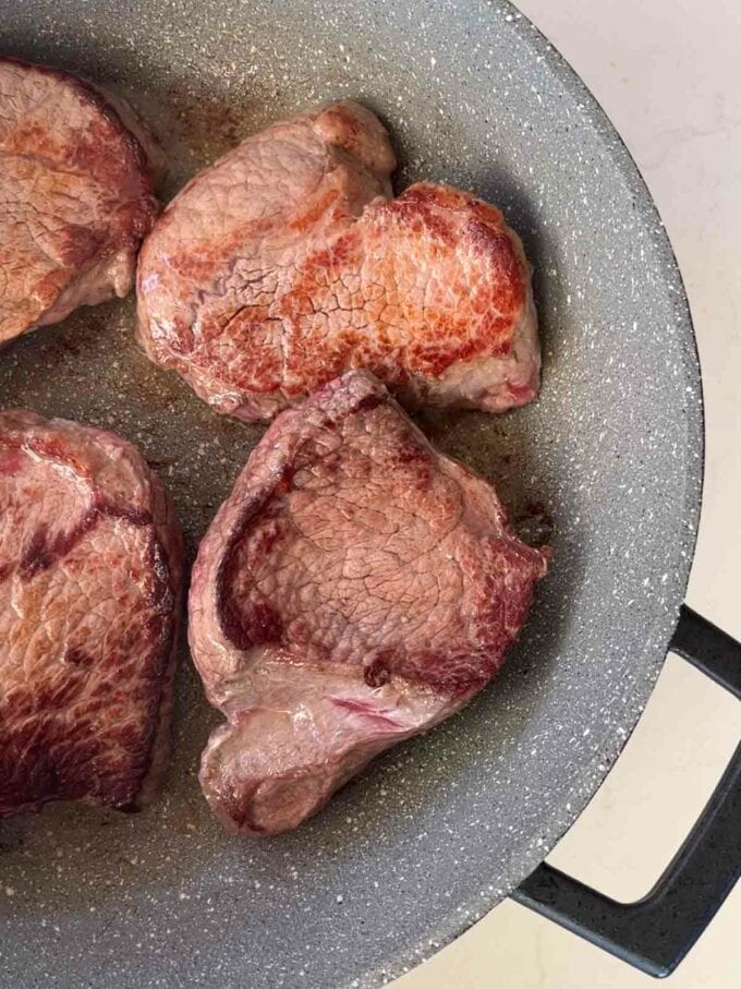 Braising steaks in a pan for Tender Braised Steak recipe. Step 1.