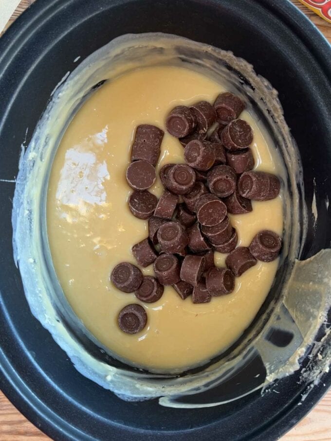 A slow cooker with melted white chocolate and condensed milk and rolos. Rolo Fudge recipe. Step 3.