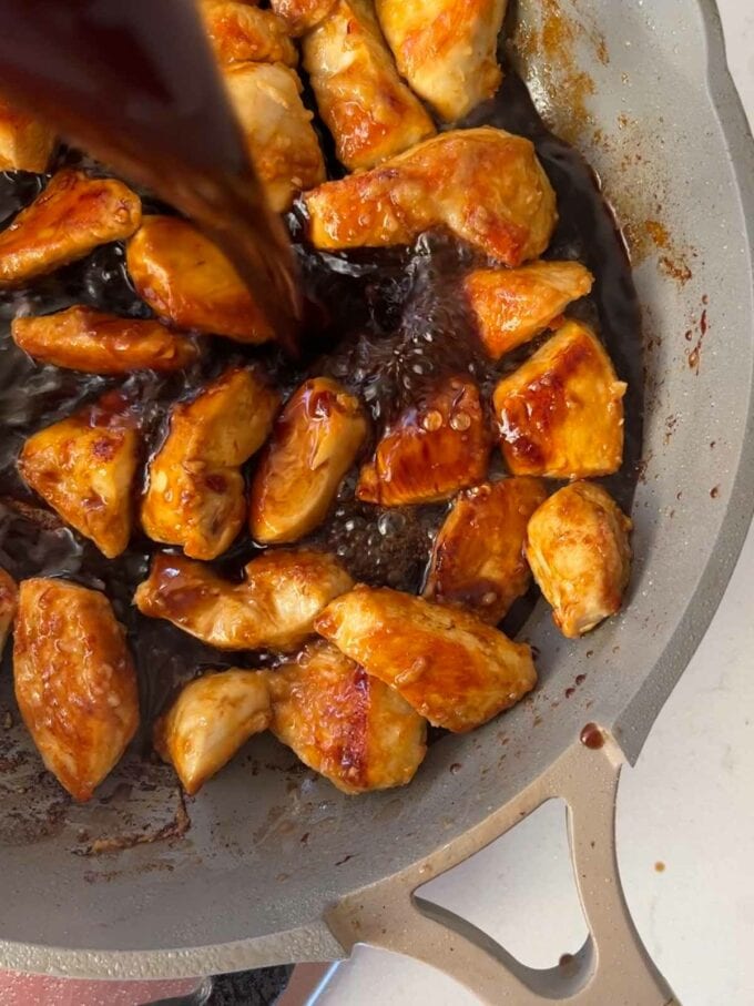 A process image of how to make teriyaki chicken. Step 2. Add the sauce to the cooked chicken in the pan.