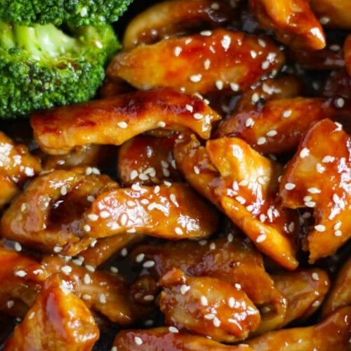 Cooked strips of chicken in a teriyaki glaze in a bowl with broccoli.