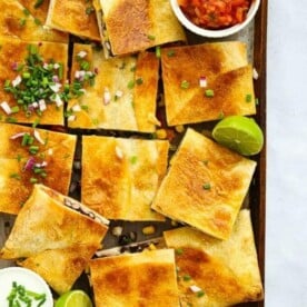 Chicken Quesadillas cut into squares with lime and salsa.