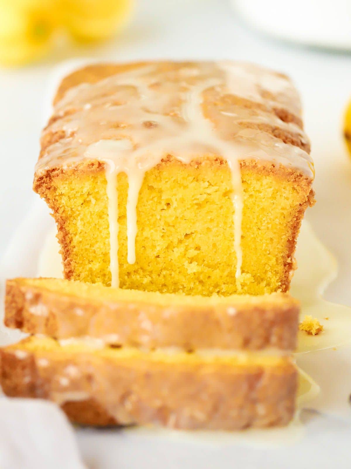 Sliced Lemon Drizzle Cake with icing topping running down the side.