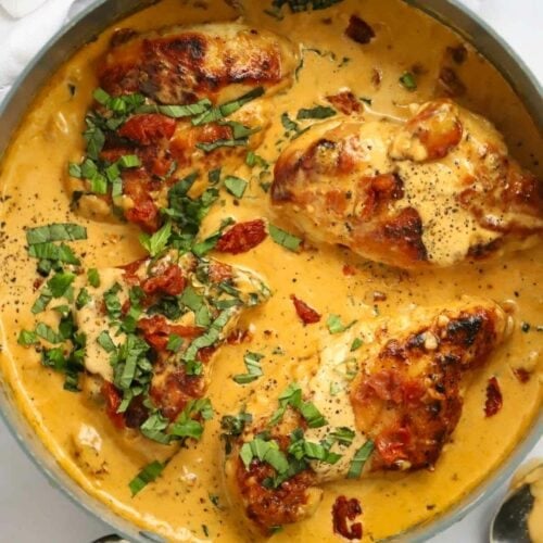 Chicken breasts in a creamy sauce and topped with basil for the recipe Marry Me Chicken.