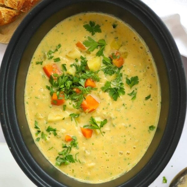 Bit slow cooker pan full of creamy vegetable soup.