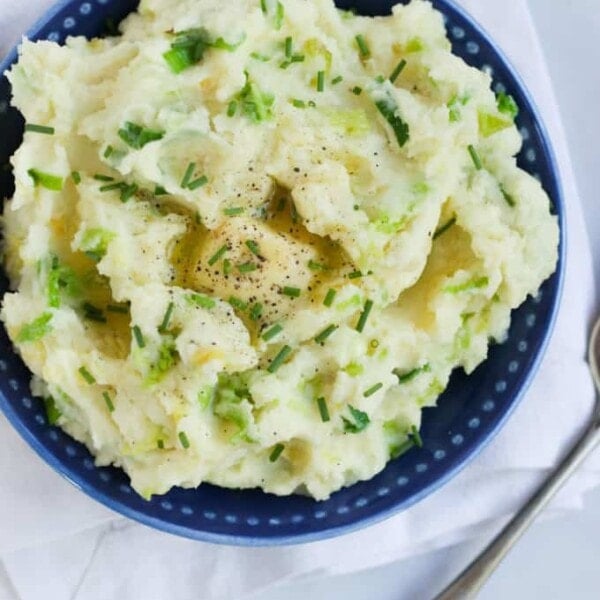 A bowl of Colcannon mashed potato on a white table cloth.