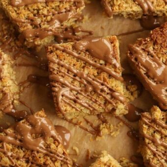 Squares of flapjack drizzled with chocolate.