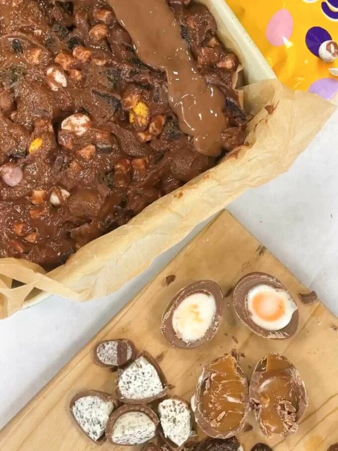 Step 2 in the recipe for Easter Rocky Road. Put all the melted chocolate into a baking tin and add easter egg toppings.