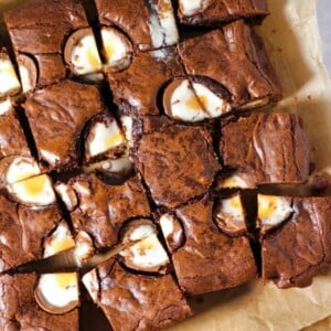 A board with cut up chocolate Creme Egg Brownies on, ready to be served.