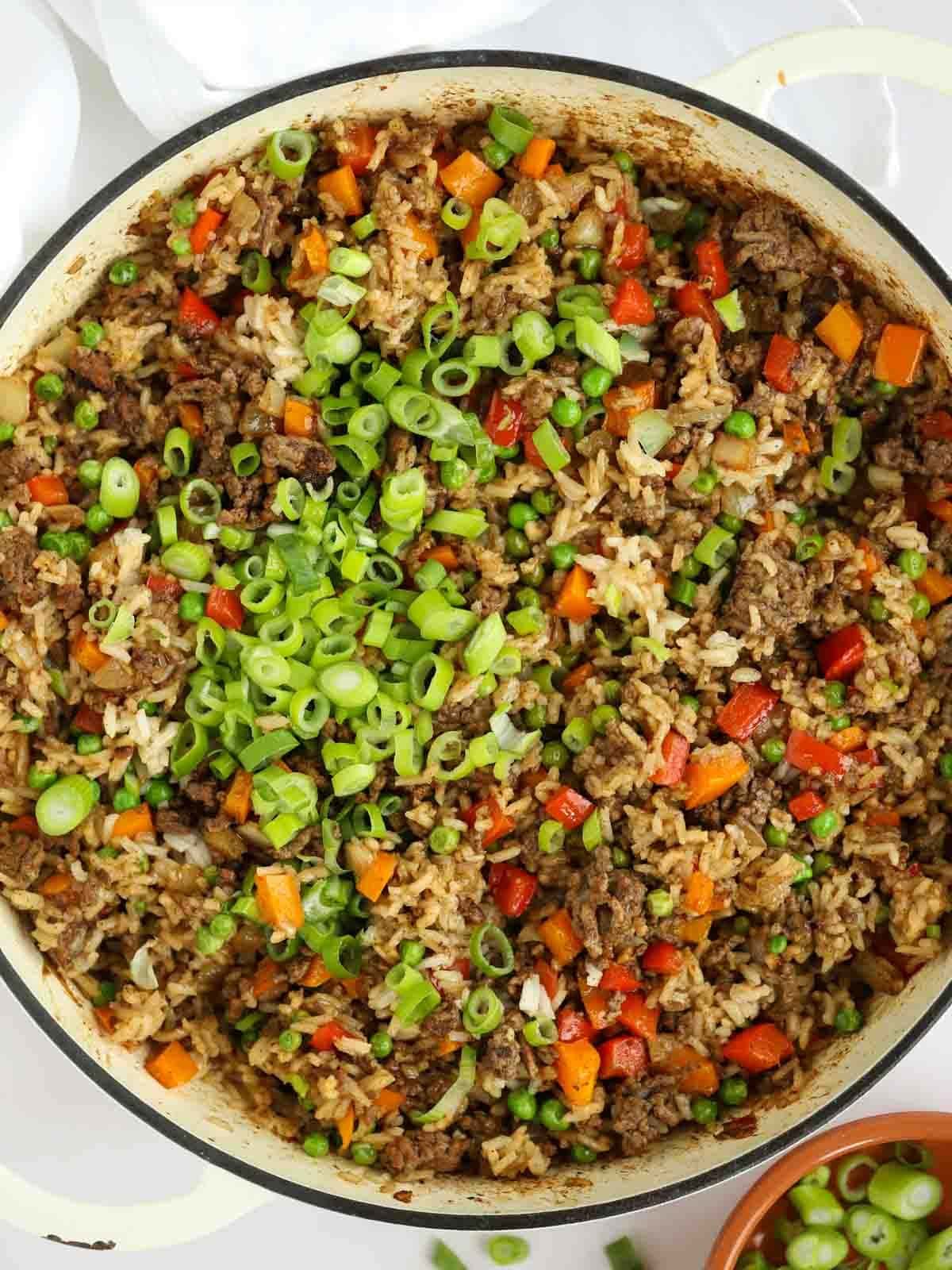 A big bowl full of beef fried rice, with peppers, onions and beef mince.