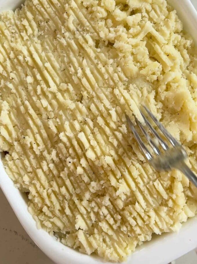 The finishing touches to the recipe Vegetarian Cottage Pie. Make grooves in the mash potato with a fork to crunch the topping up.