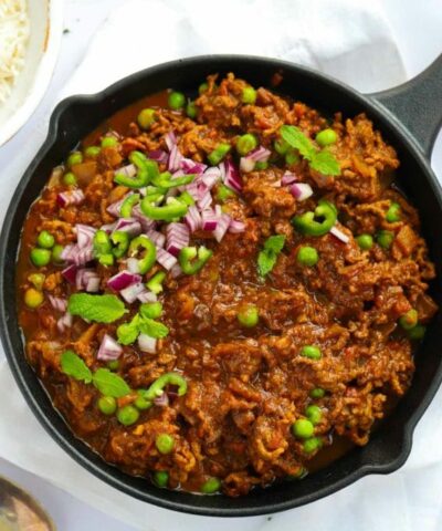 A big pan full of beef mince keema curry with peas and chillies.