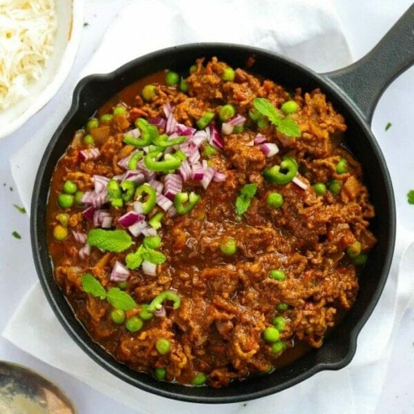 A big pan full of beef mince keema curry with peas and chillies.
