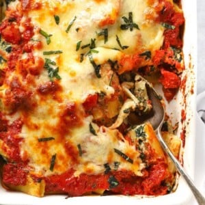 A dish with cooked Spinach and Ricotta Pasta Bake, topped with cheese, ready to be served.