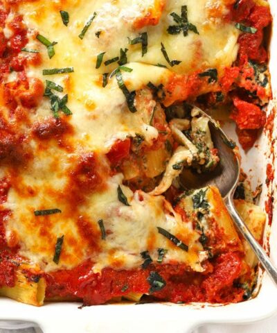 A dish with cooked Spinach and Ricotta Pasta Bake, topped with cheese, ready to be served.