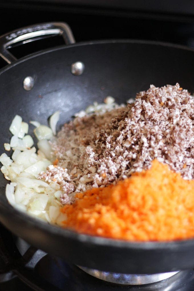 A pan with finely chopped onions, carrot and mushrooms for the recipe Pork Yuk Sung. Step 1.