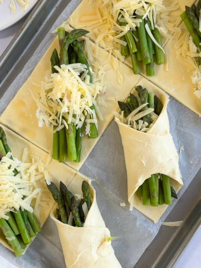 Step 3 in the recipe for Cheese & Asparagus Puff pastry parcels. Wrap the corners of pastry over the top of the filling.