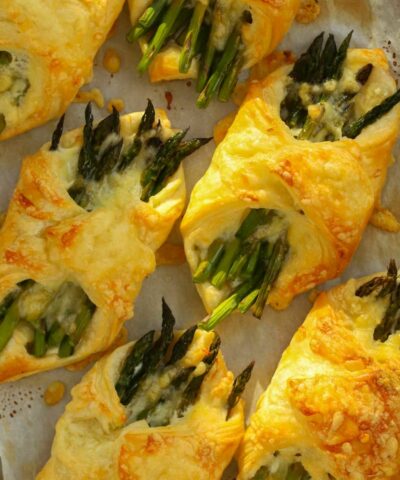 Cheese and asparagus wrapped in a puff pastry parcels. Golden brown and straight out of the oven.