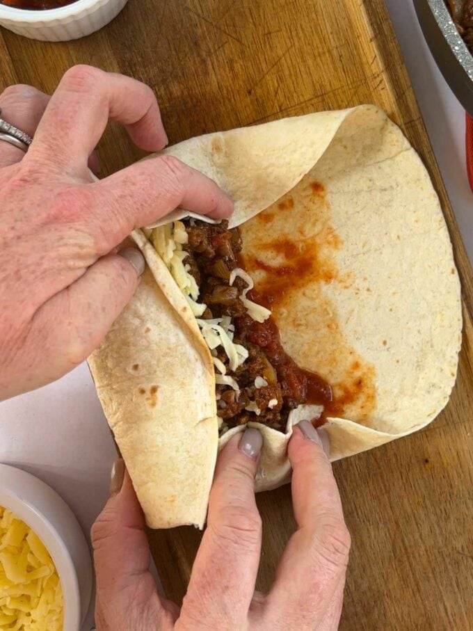How to make Beef Burritos. Step 4. Wrap the tortilla up tightly with the filling inside.