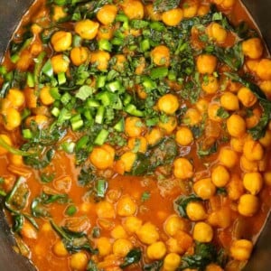 Chickpeas and spinach in a tomato, creamy sauce in the slow cooker for a vegetarian Chana Saag recipe.