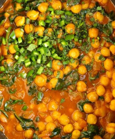 Chickpeas and spinach in a tomato, creamy sauce in the slow cooker for a vegetarian Chana Saag recipe.
