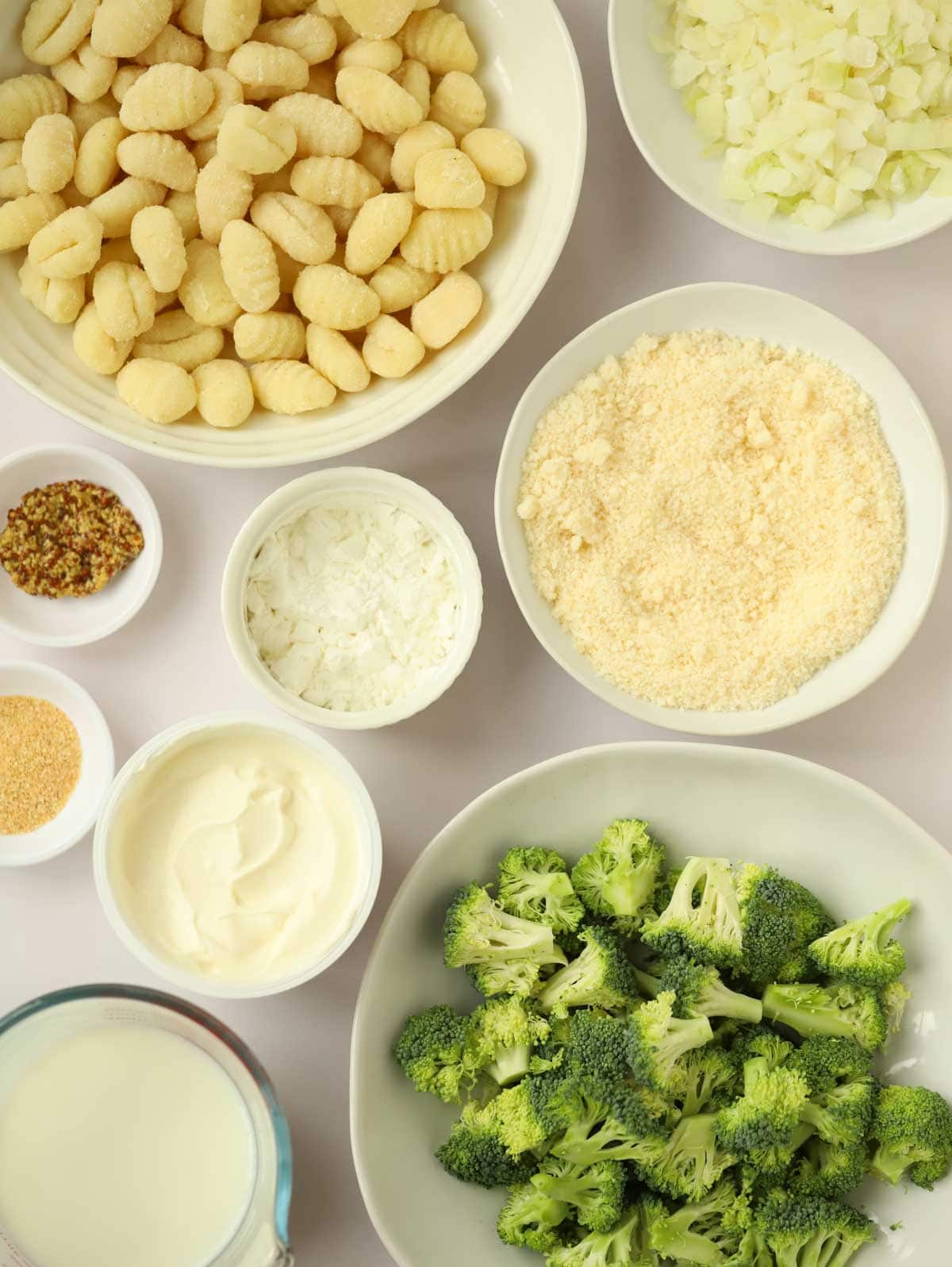 Ingredients to make baked gnocchi, broccoli, parmesan, milk, cornflour, creme fraiche