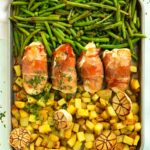 Recipe for bacon wrapped chicken served with potatoes and green beans.