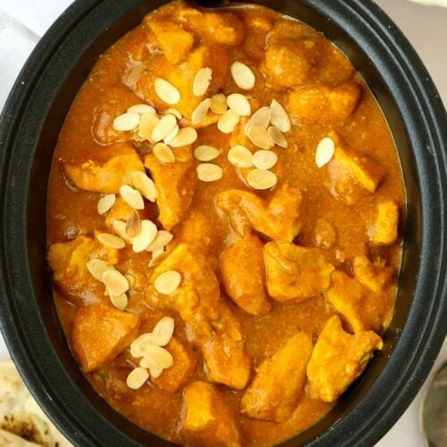 Big chunks of cooked chicken in a korma curry sauce, ready to serve after being cooked in the slow cooker.