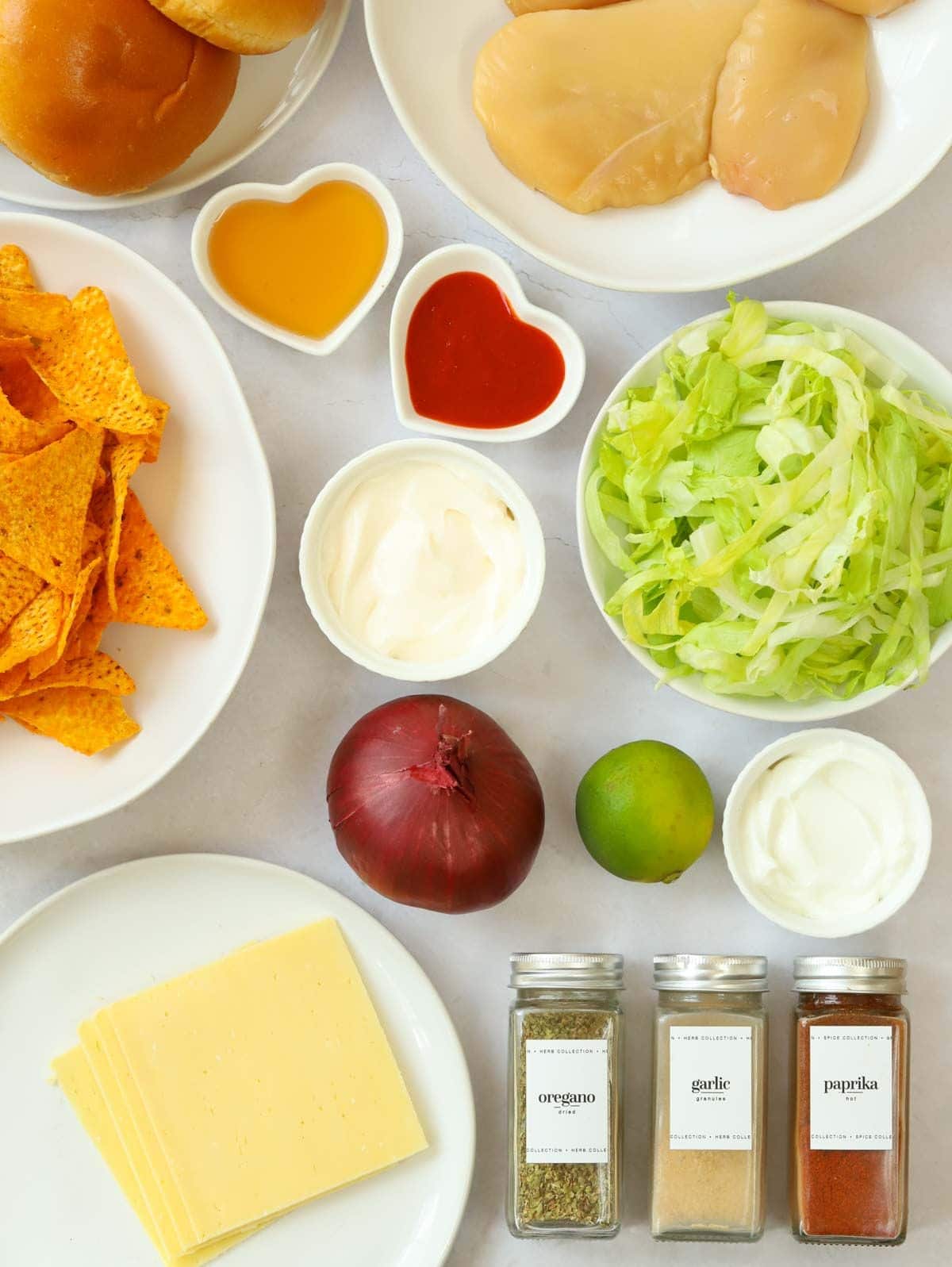 The rain ingredients for making Crispy Chicken Burgers laid out on a counter.