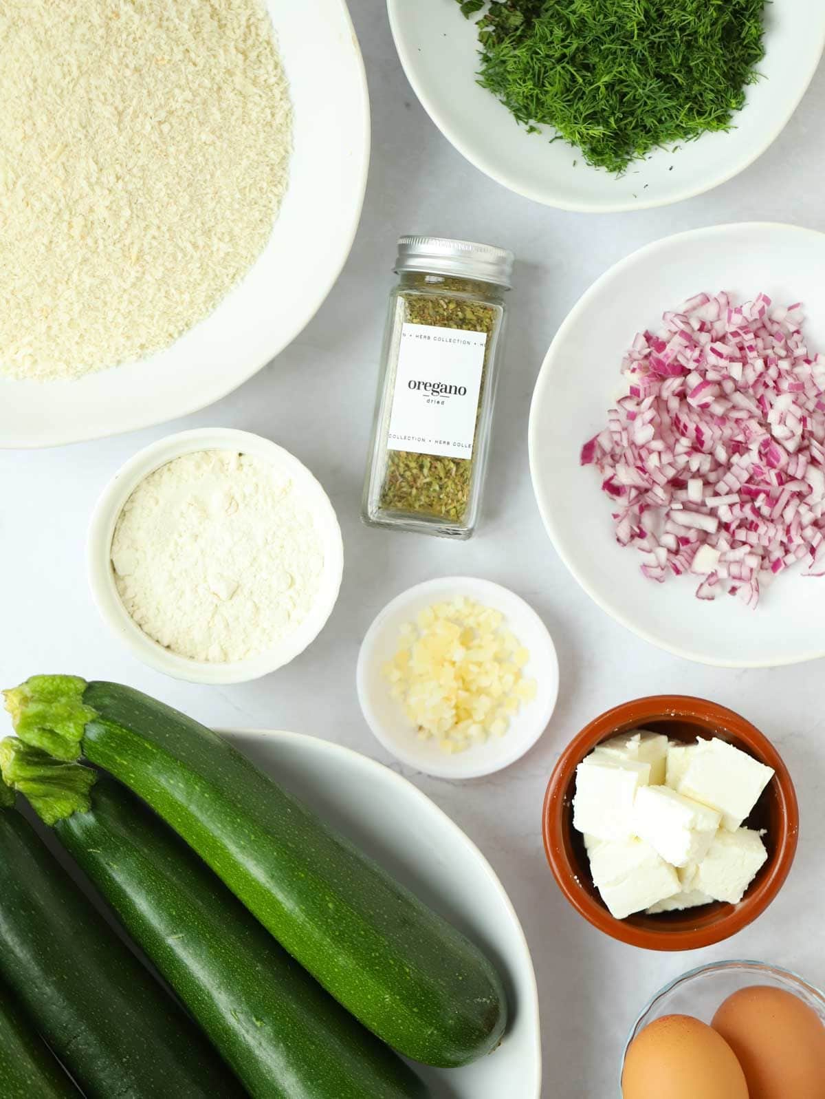 The ingredients to make courgette fritters laid out on a counter top.