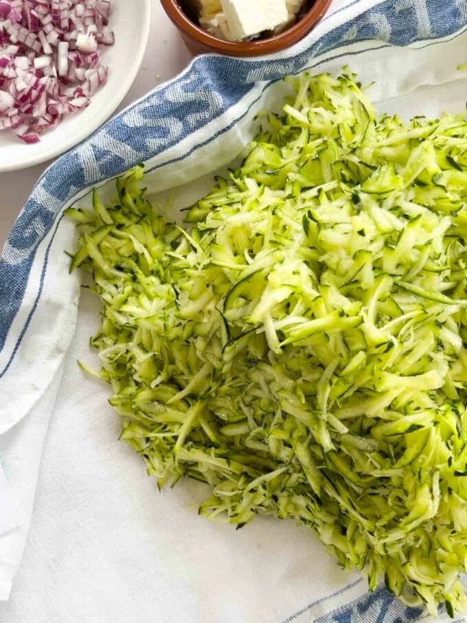 How to make Courgette Fritters. Step 1. Grate and dry the courgettes well.