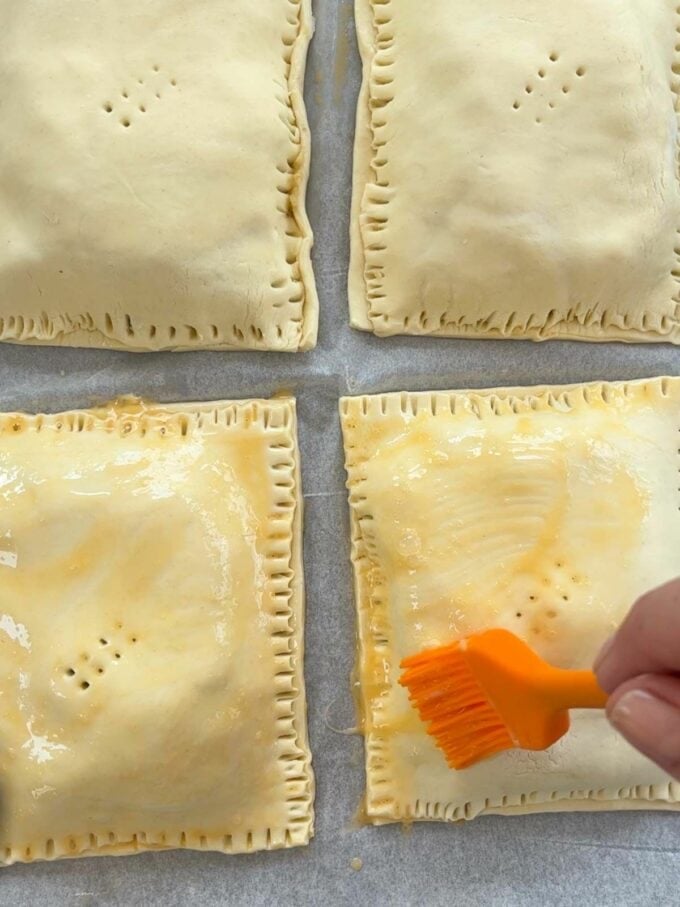 How to make Cheese and Onion pasties. Step 4. Press on the top pastry layer and brush egg wash on the whole thing.