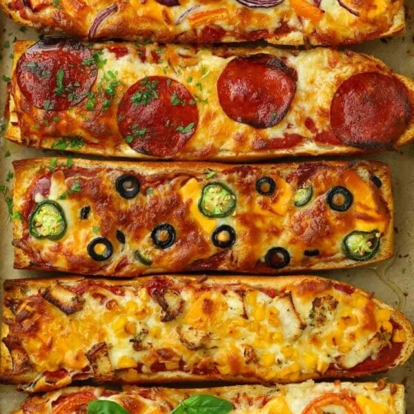 Easy French bread pizzas with pepperoni topping, another with olives, another with sweetcorn.