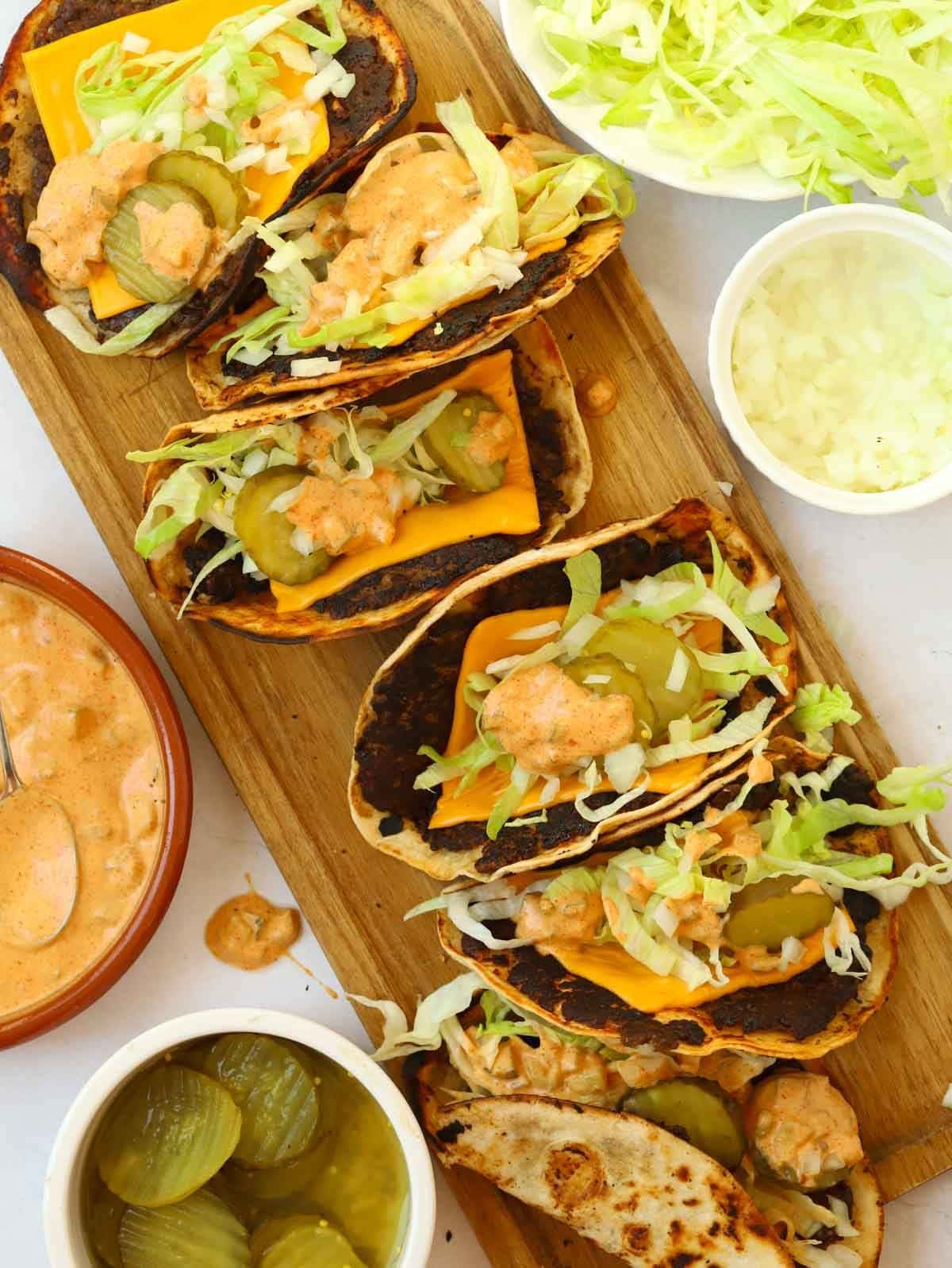A serving board filled with Big Maco Tacos and side dishes.