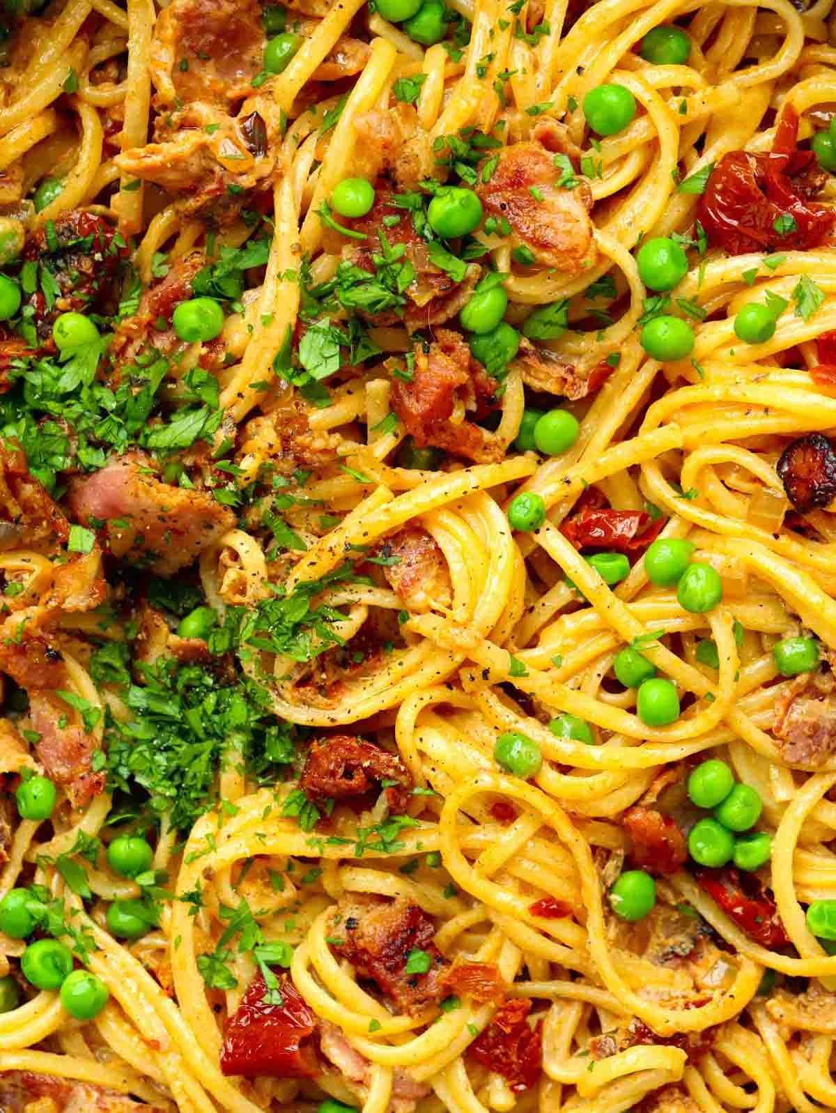 A mixture of bacon, peas and spaghetti ready to eat.