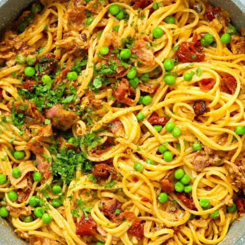 Big pan of Bacon Spaghetti Pasta with peas and creamy sauce.