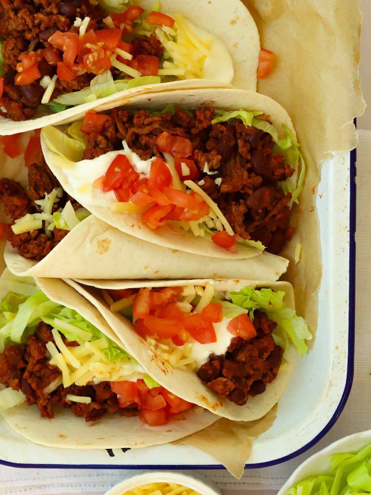 A baking tray filled with beef tacos and stuffed with salad.