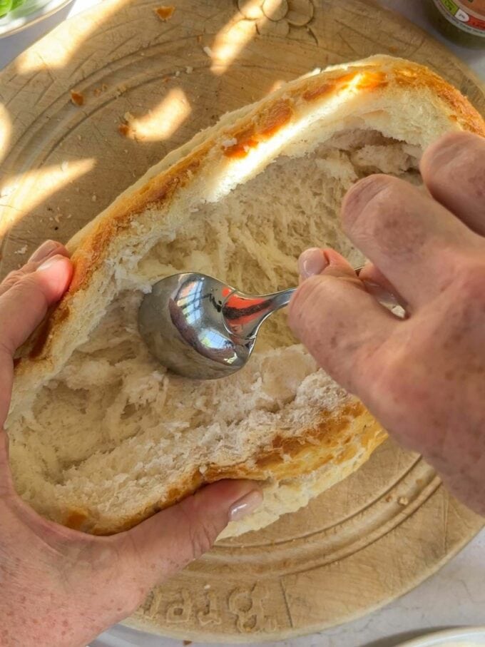 Step 1 in the method of how to make a stuff picnic loaf. Hollow out a loaf of fresh bread and remove the inside.