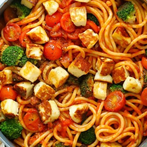 A large pot filled with spaghetti and halloumi with a tomato sauce and broccoli for a quick 15 minute meal.