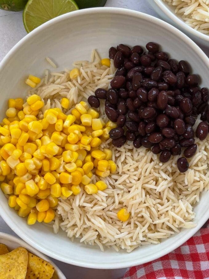 No cook burrito bowls recipe, step 1. Add the rice, sweetcorn and beans to a bowl.