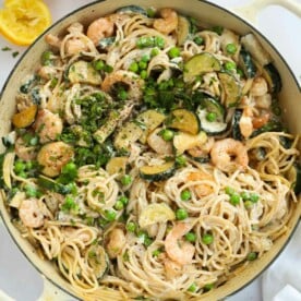 A big bowl fill of prawn pasta with courgettes, peas, prawns and spaghetti, ready to eat.