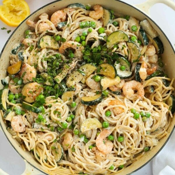 A big bowl fill of prawn pasta with courgettes, peas, prawns and spaghetti, ready to eat.