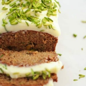 A sliced Courgette Cake topped with pistachios, ready to eat.