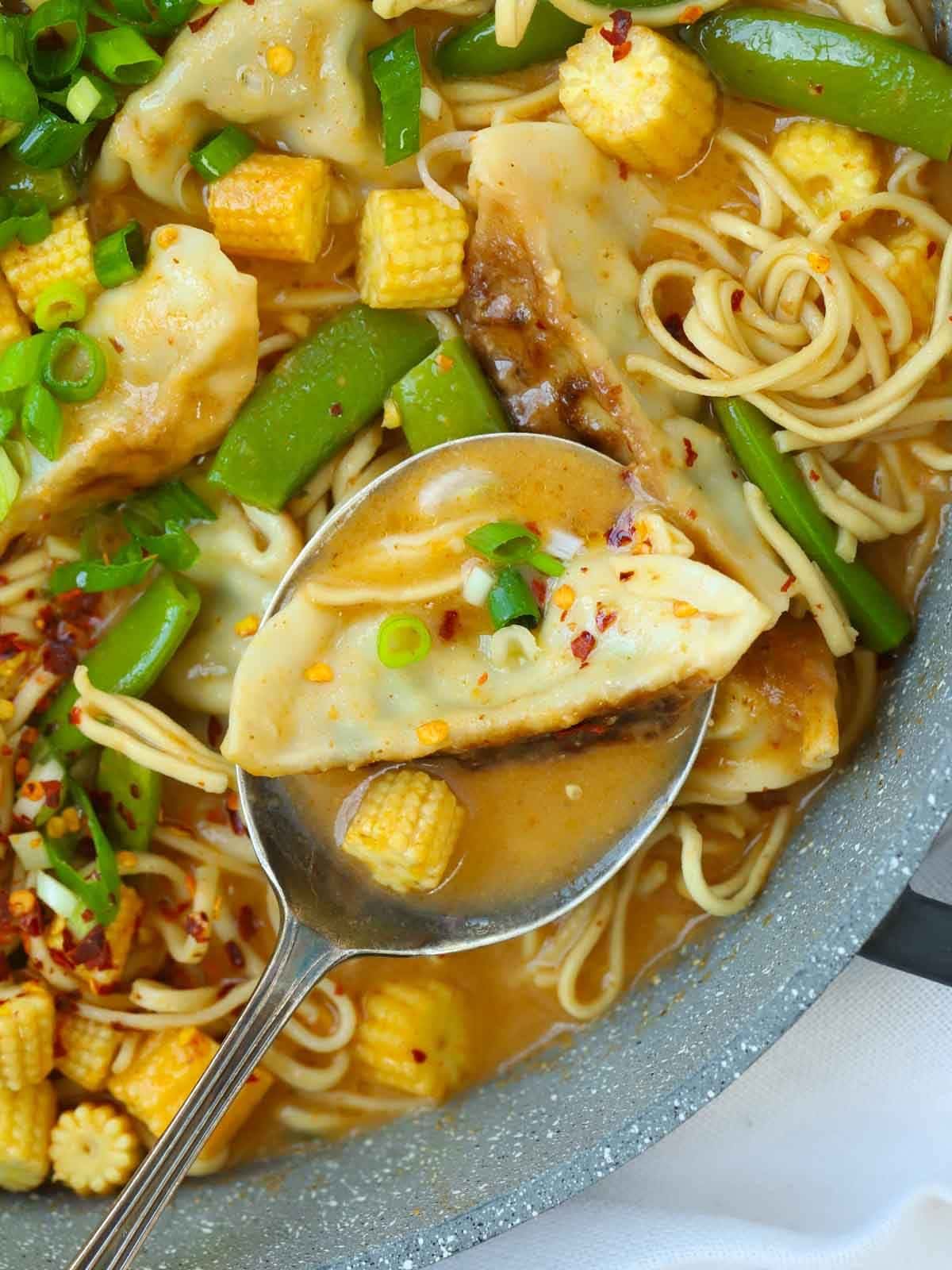 A spoon dishing up a mouthful of Gyoza Soup.