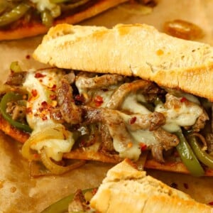 A baguette filled with hot melted cheese and steak for a homemade Philly Cheesesteak that's ready to eat.