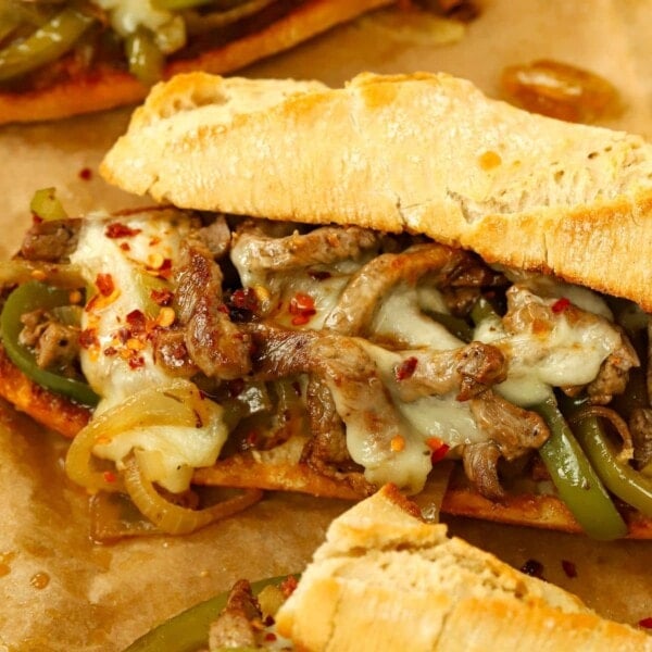 A baguette filled with hot melted cheese and steak for a homemade Philly Cheesesteak that's ready to eat.