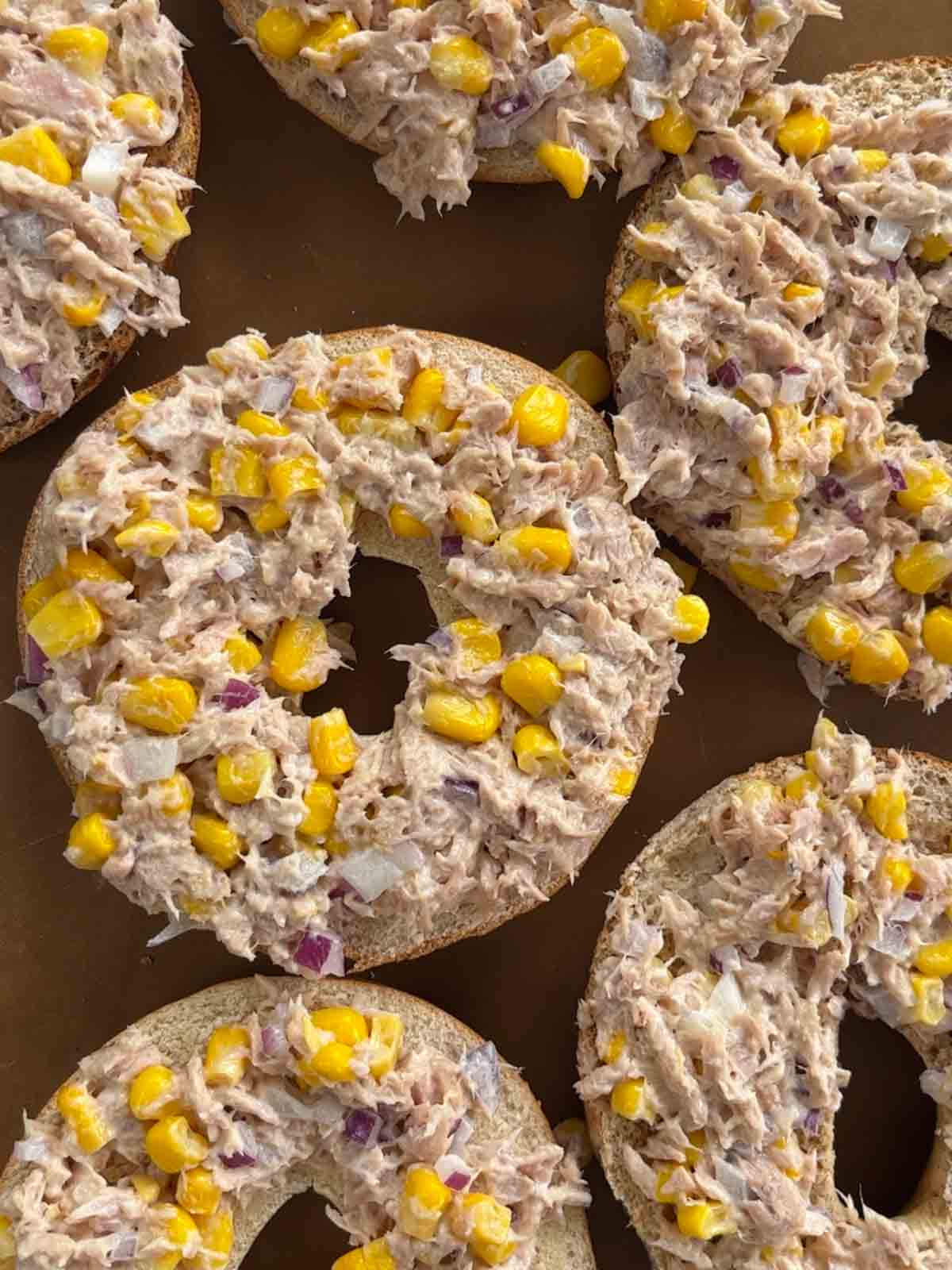 Step 3 of making tuna melt bagels topping with tuna mixture and sweetcorn mixture.