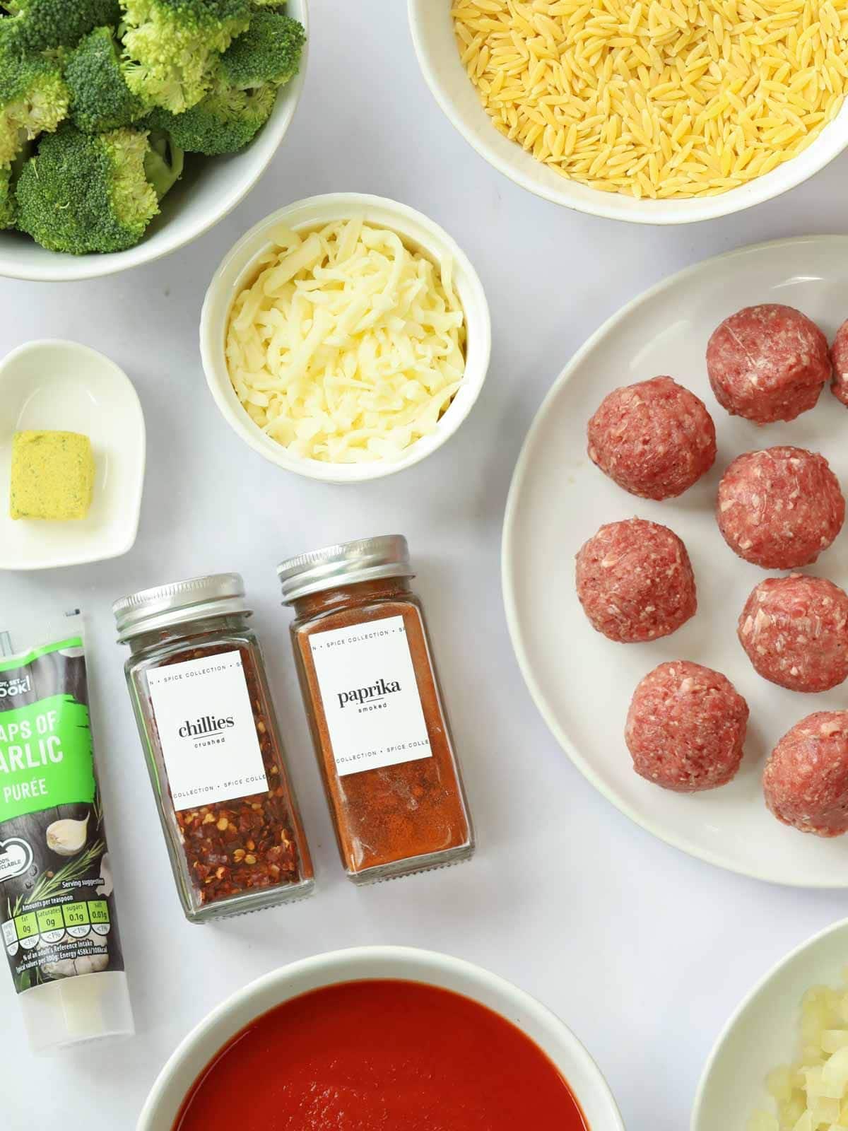 Ingredients for a meatball orzo bake recipe all laid out on a counter.