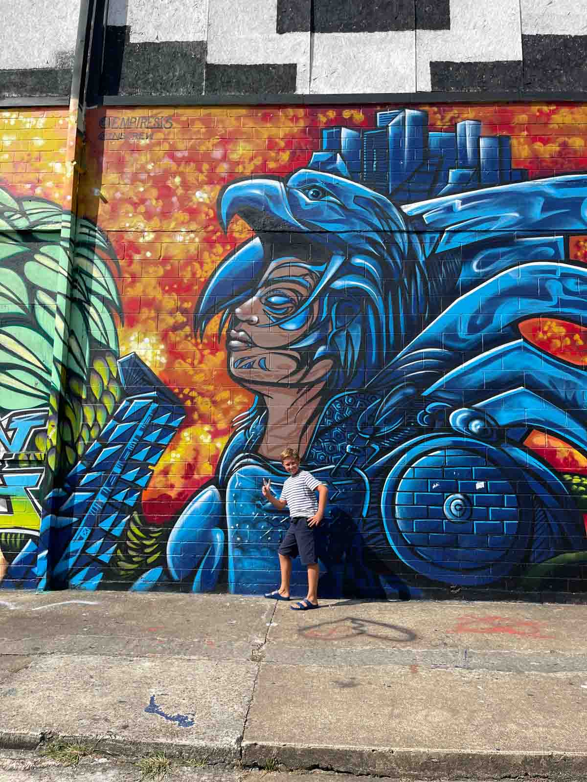 Houston graffiti wall with boy standing in front.